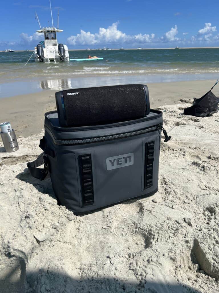 Bluetooth speaker playing music on the beach.